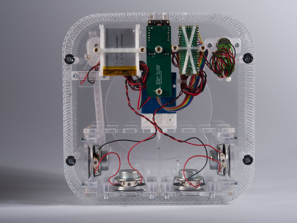The internal speaker box split into two sealed chambers, mounted inside the transparent shell.
