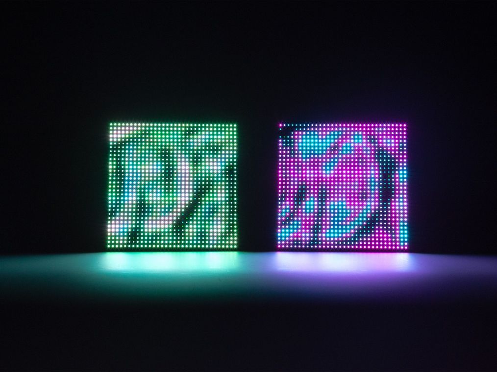 The two connected units side by side, one glowing green and the other magenta, each showing its own rippling pond of light.
