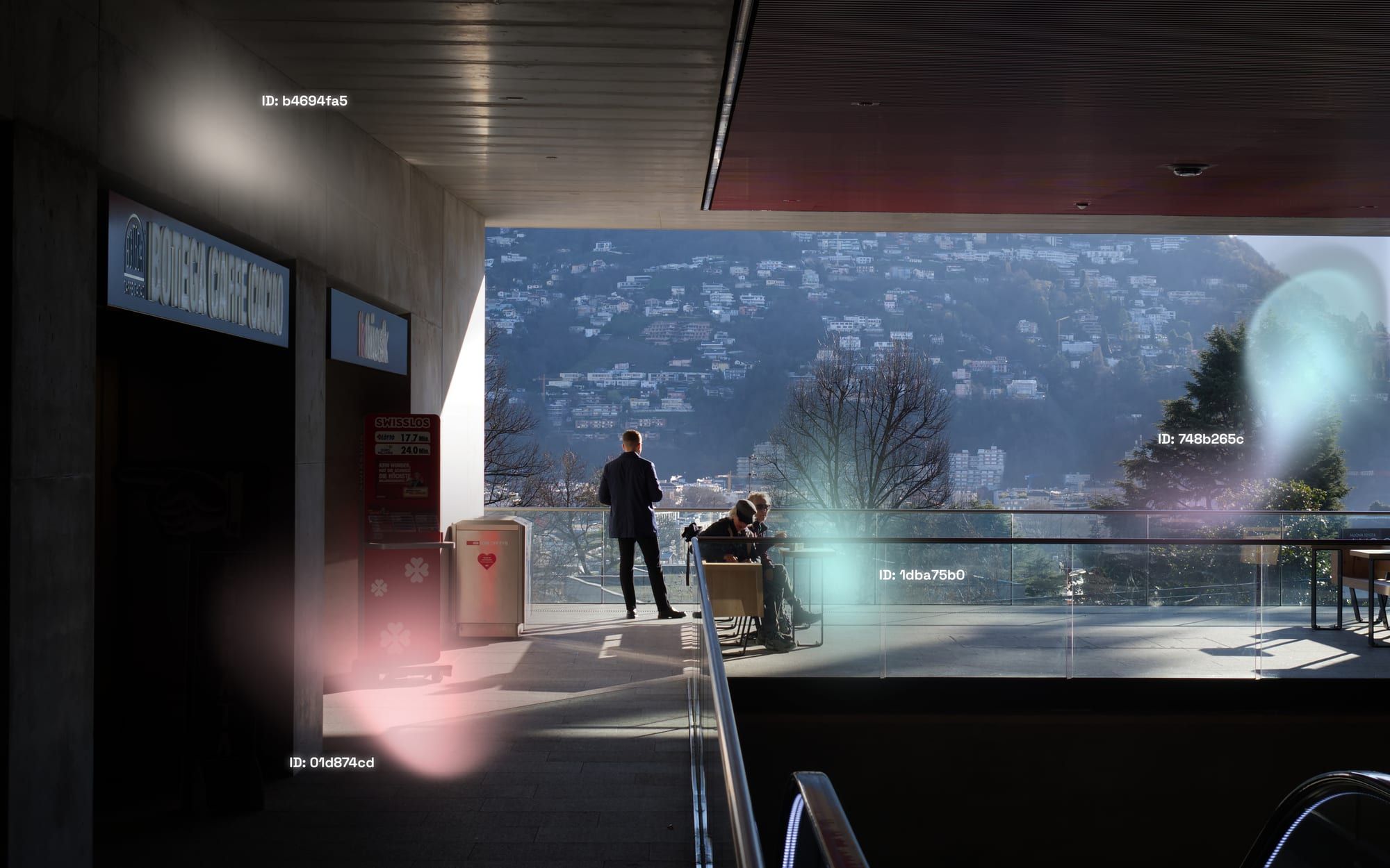 An ELEN capture on a terrace overlooking Lugano: translucent colored apparitions of different sizes drift over the scene, each tagged with an anonymized hexadecimal identifier.