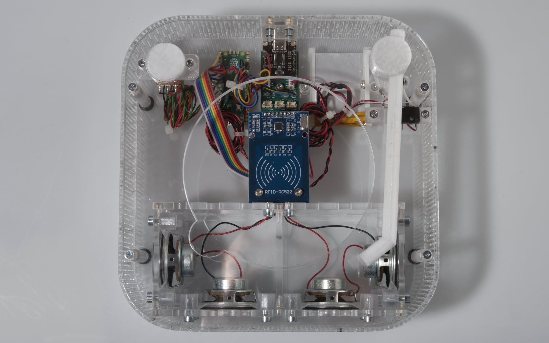 An angled top-down through the transparent shell: boards and the platter sit on 3D-printed internal supports fixed with heat-set inserts, keeping the outer surfaces clean.